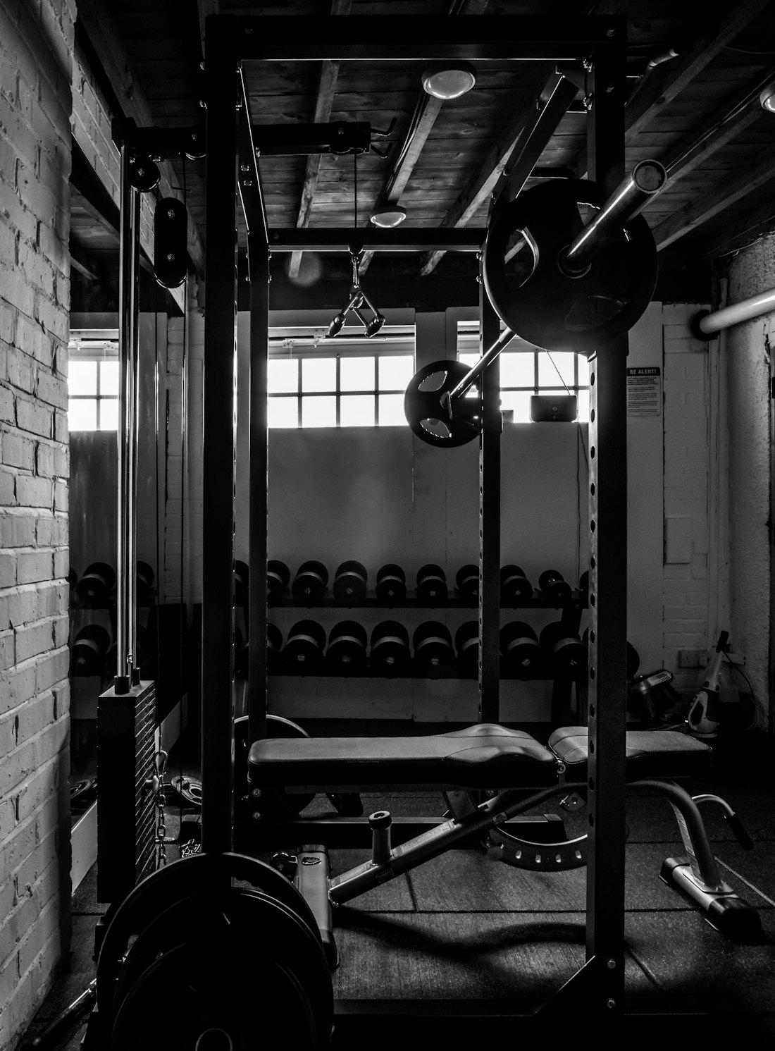 Tuğla duvar önünde squat rack ve barfiks istasyonu