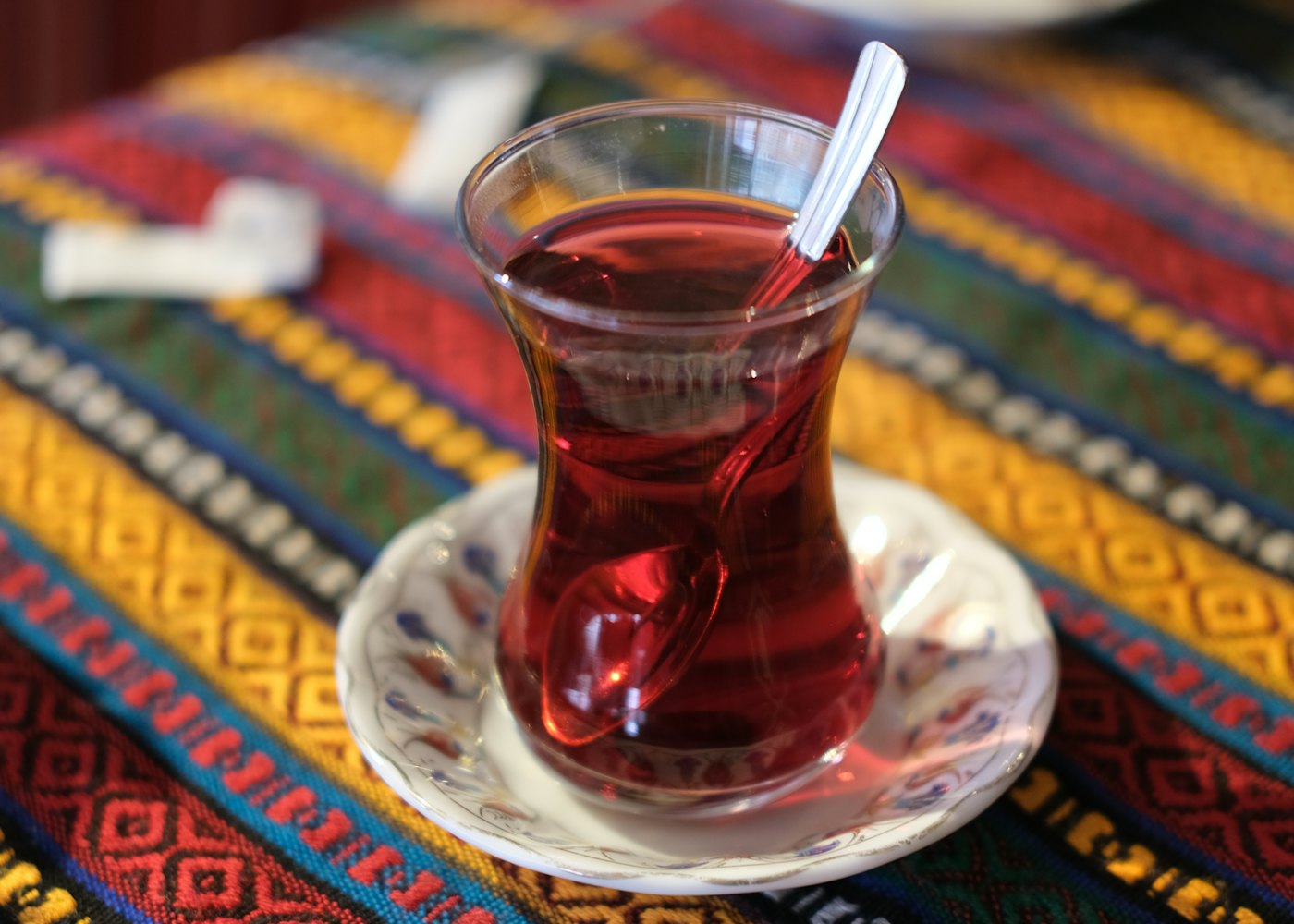 Renkli kilim üzerinde ince belli bardakta çay