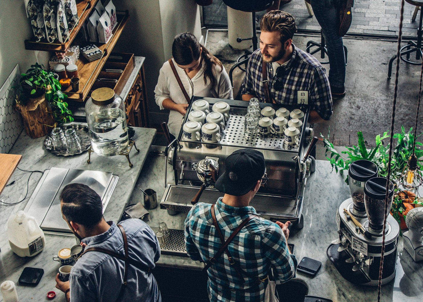 Overhead view of baristas working together at a busy espresso bar