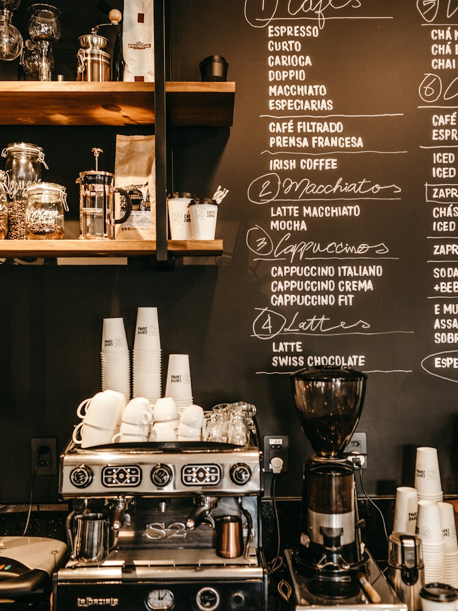 Espresso machine and grinder in front of a chalkboard menu