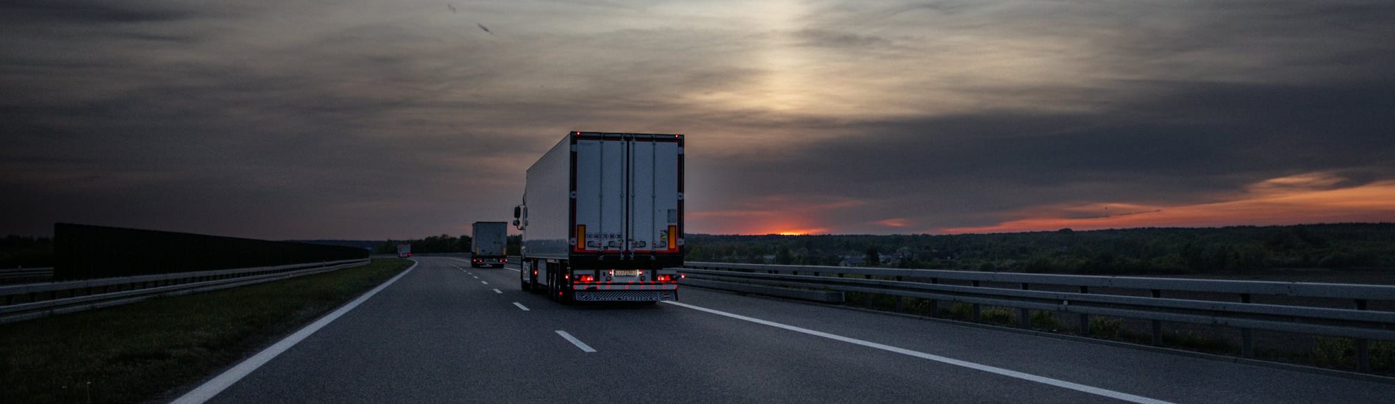 A refrigerated lorry on a motorway at dusk