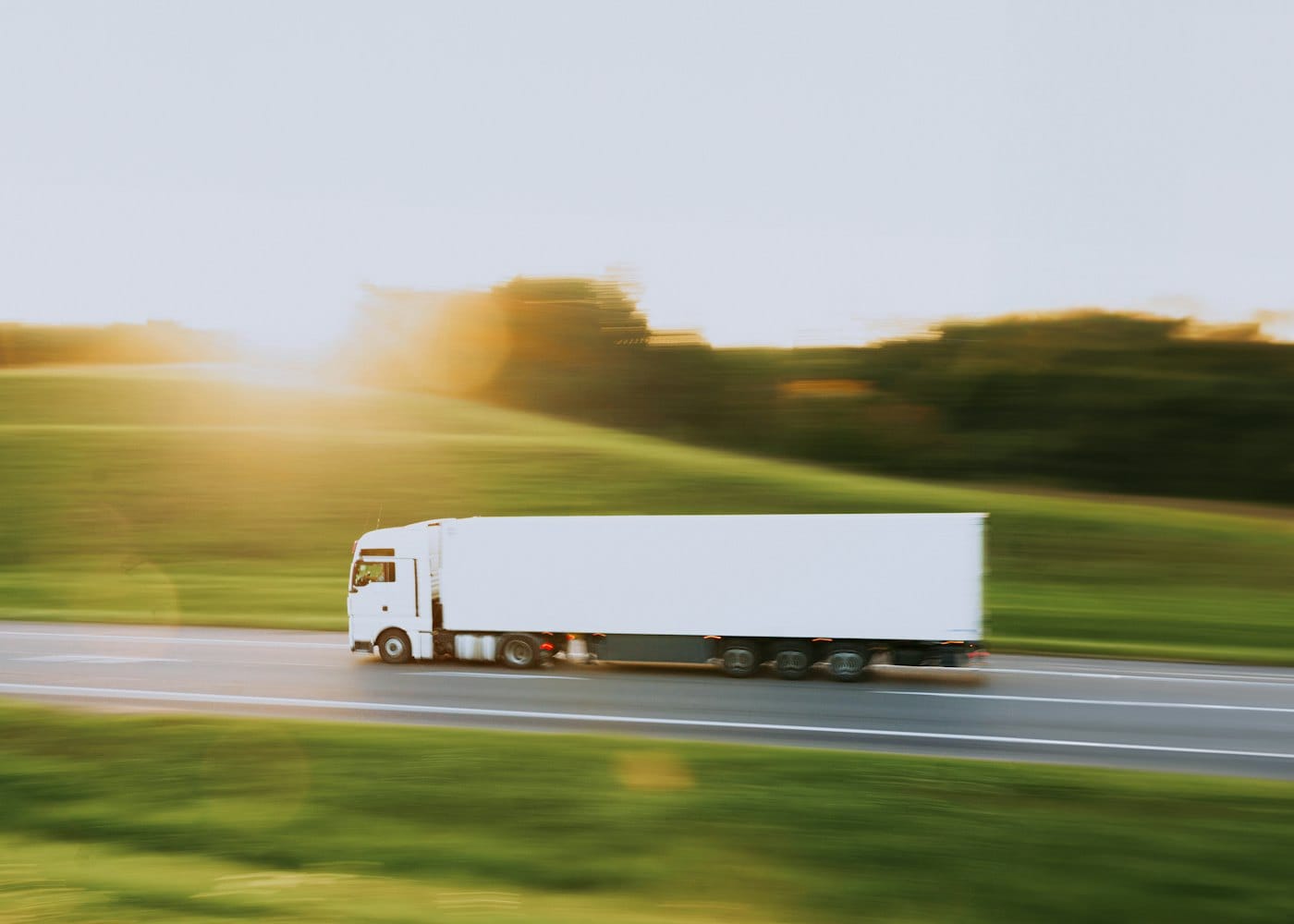 A white refrigerated lorry speeding along a motorway