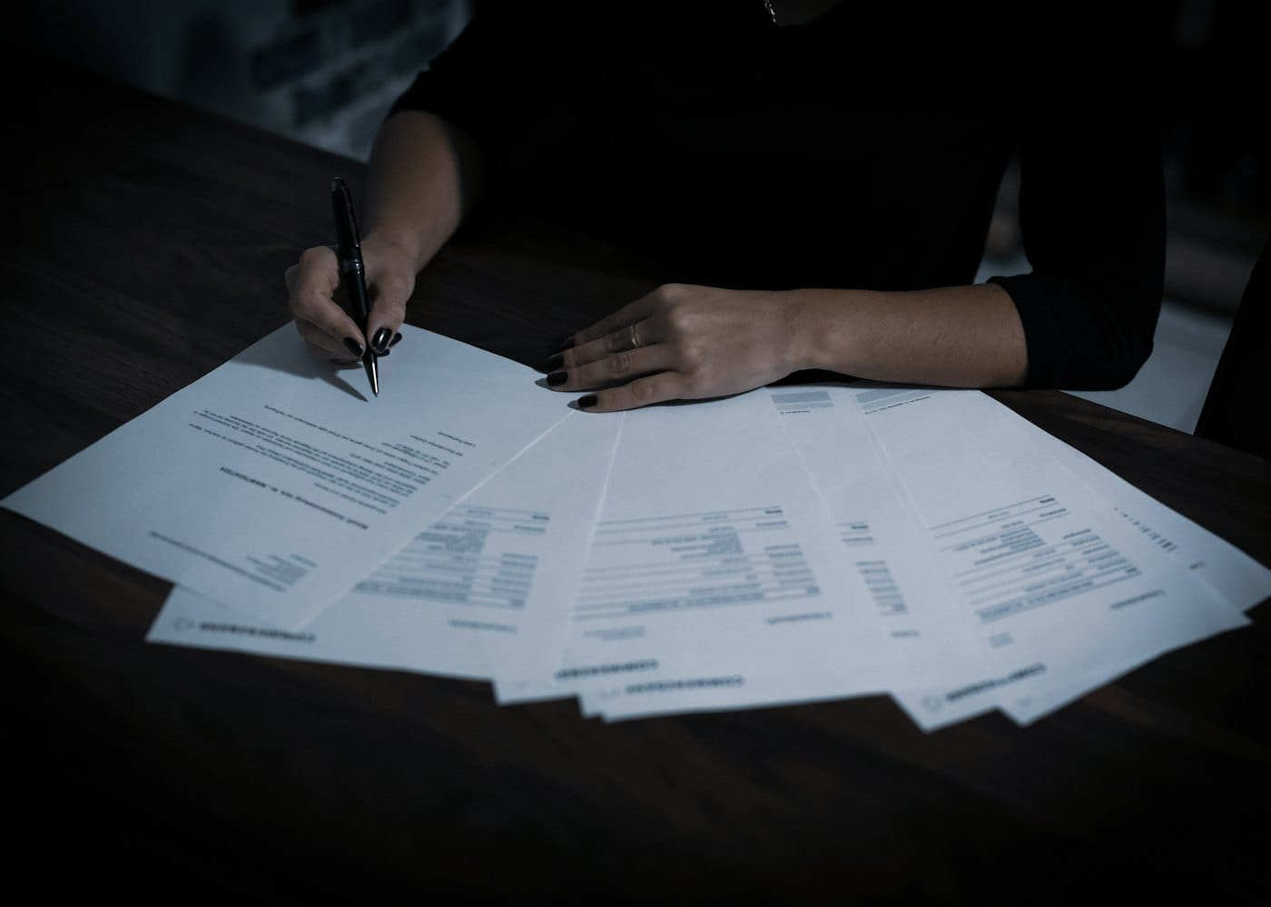 A customs broker signing export documents at a desk