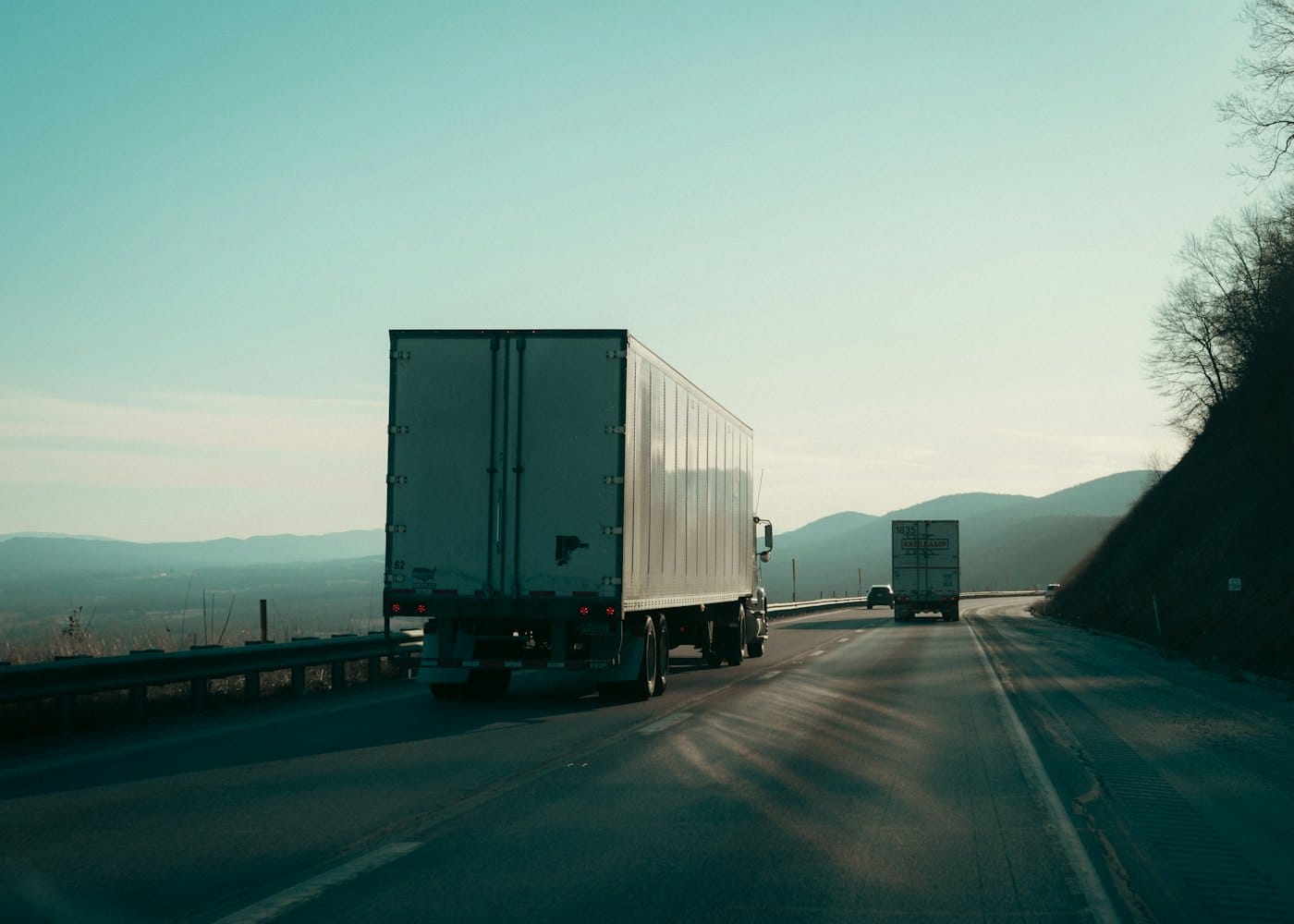 Two curtain-sided lorries on a mountain road