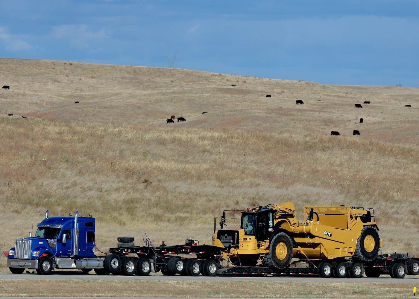 A large earthmover carried on a lowloader trailer
