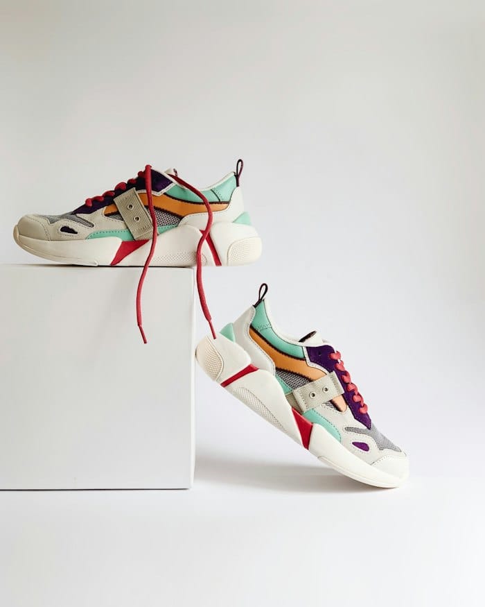 A pair of colourful trainers on a white plinth