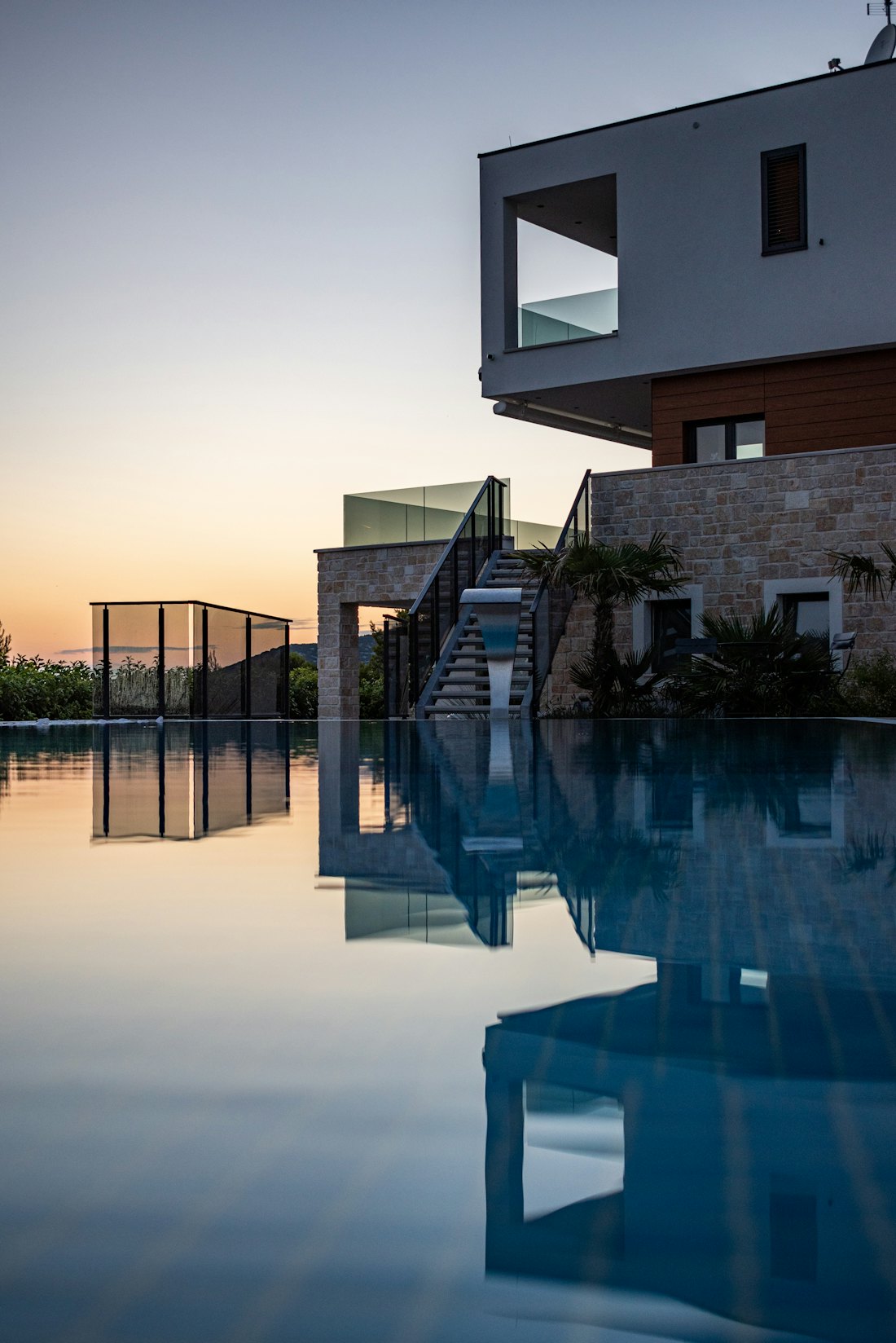 The pool and stone façade in evening light