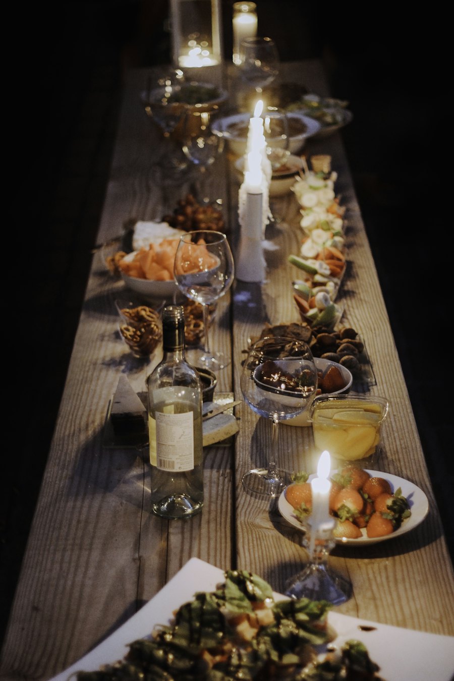 A long dinner table lit by candles