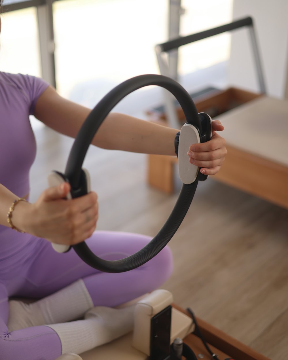 Reformer aletinde pilates çemberiyle çalışan üye