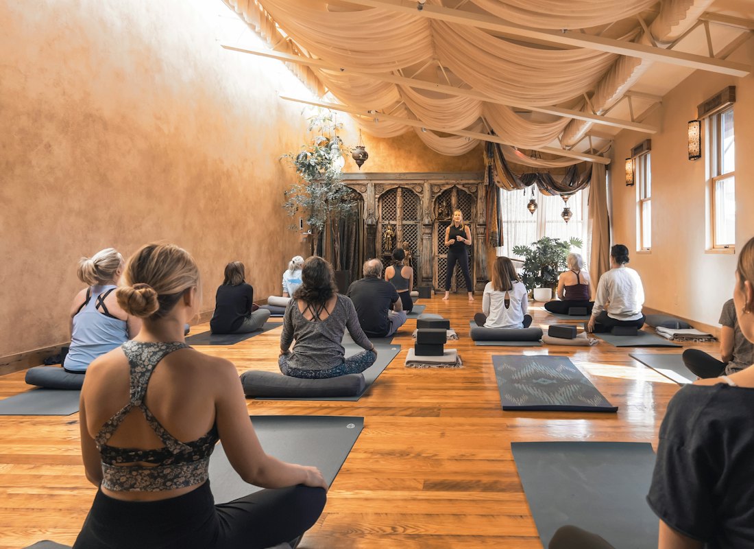 Ahşap zeminli sıcak bir salonda meditasyon yapan yoga grubu