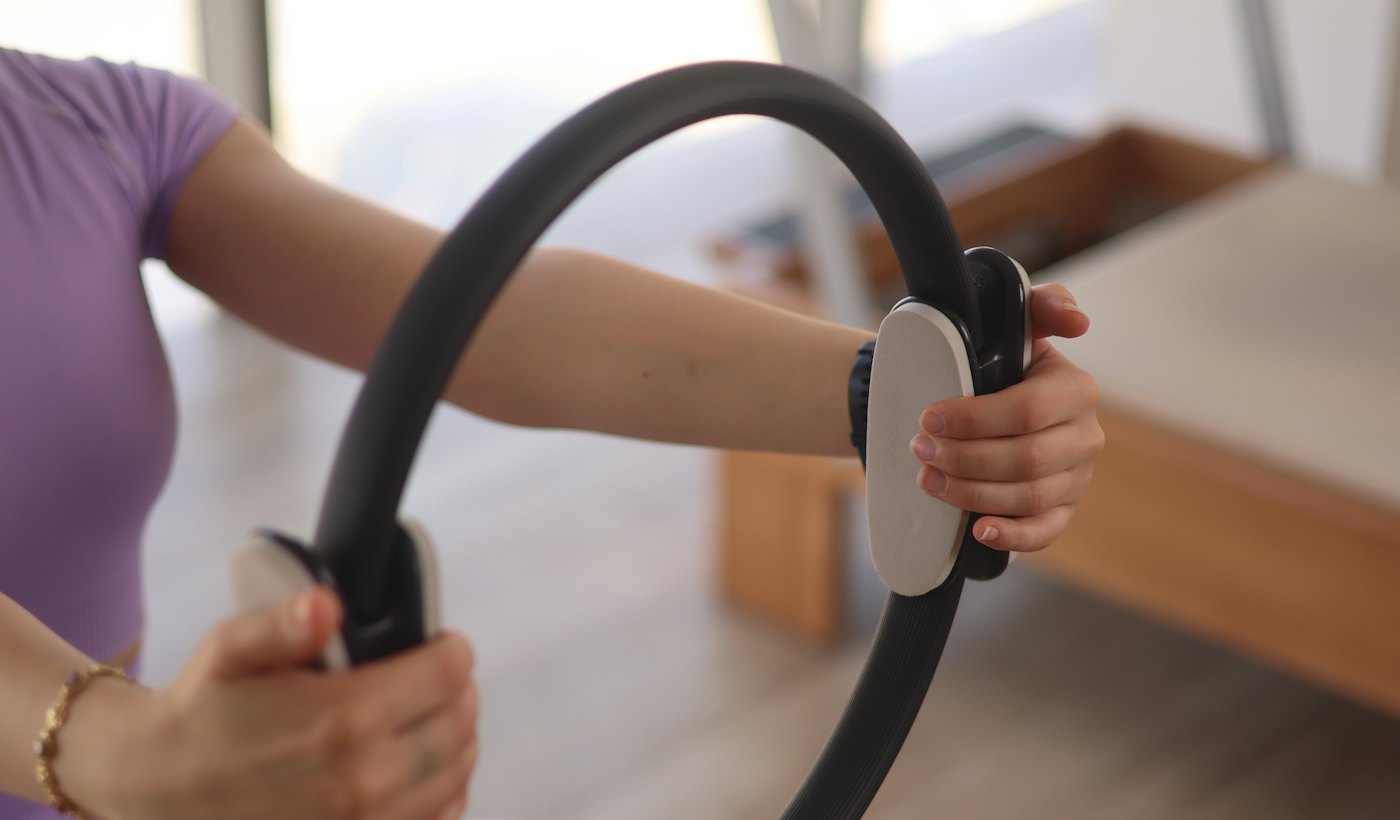 Reformer üzerinde pilates çemberiyle çalışan üye