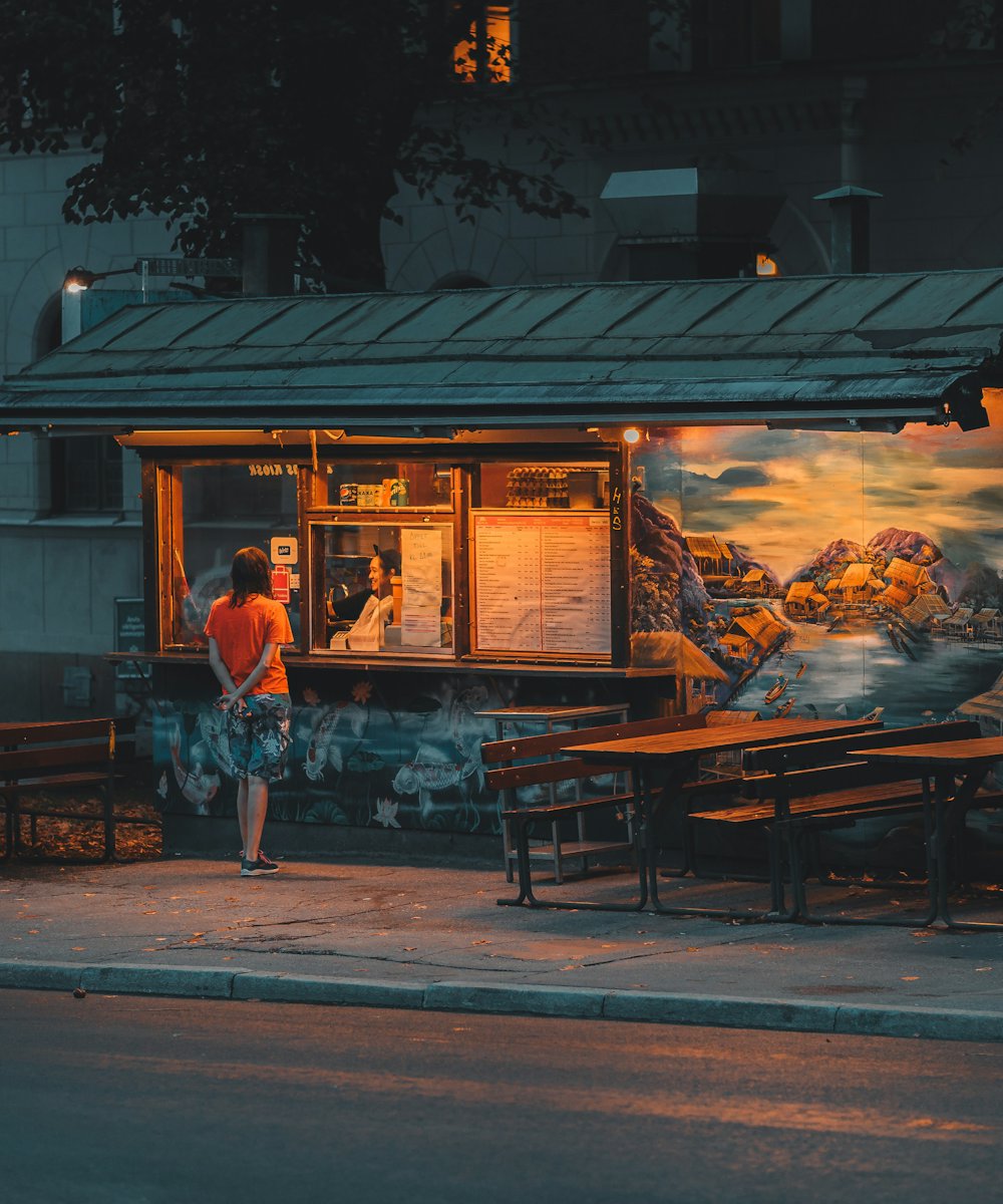 Kadıköy'de akşamüstü ışıkları yanmış küçük bir büfe ve önündeki masalar