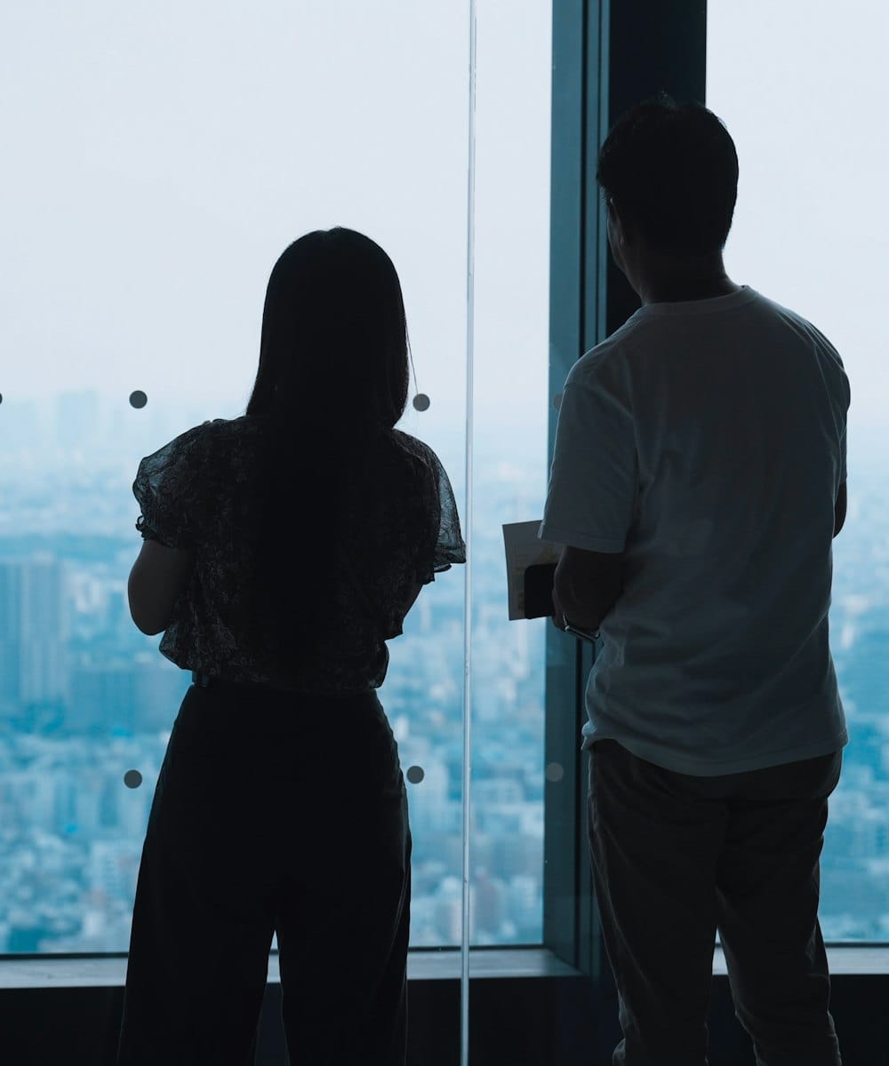 Two colleagues looking out over the city from the office window