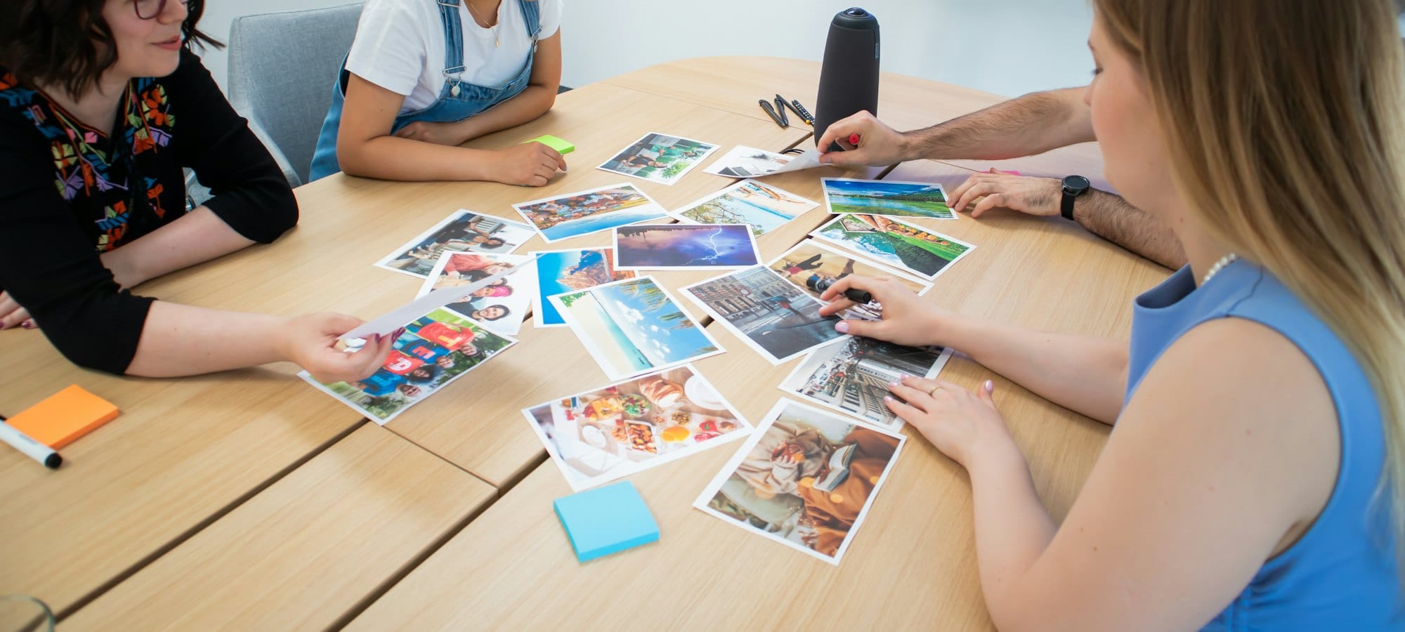 Agency team reviewing printed campaign images around a meeting table