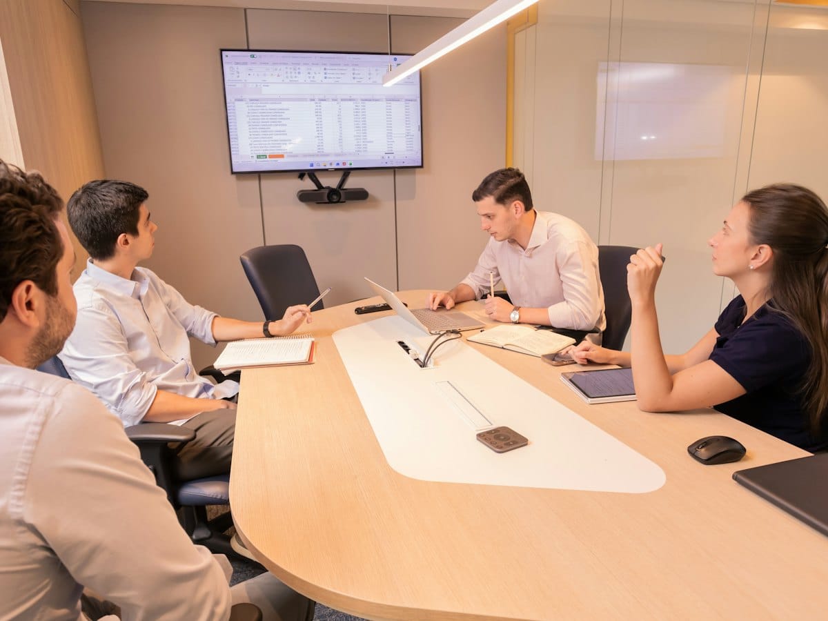A meeting table reviewing a media plan on screen