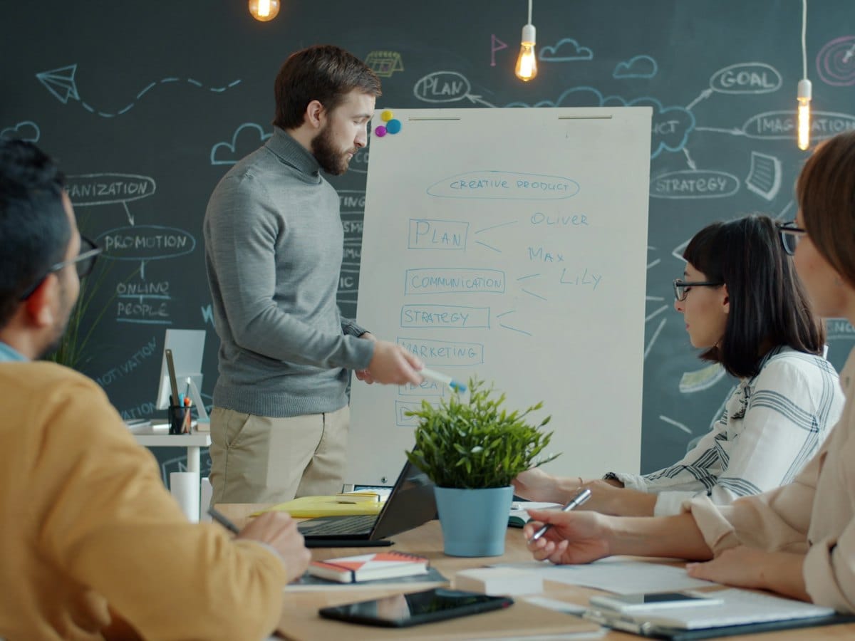 A strategist presenting a brand plan in front of a whiteboard