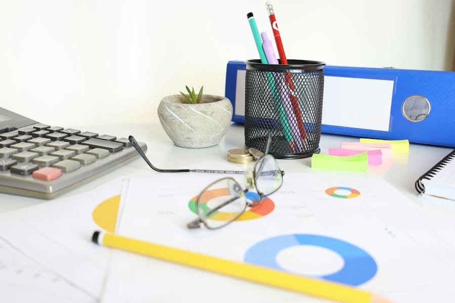 Research notes on a desk with charts, pens and a calculator
