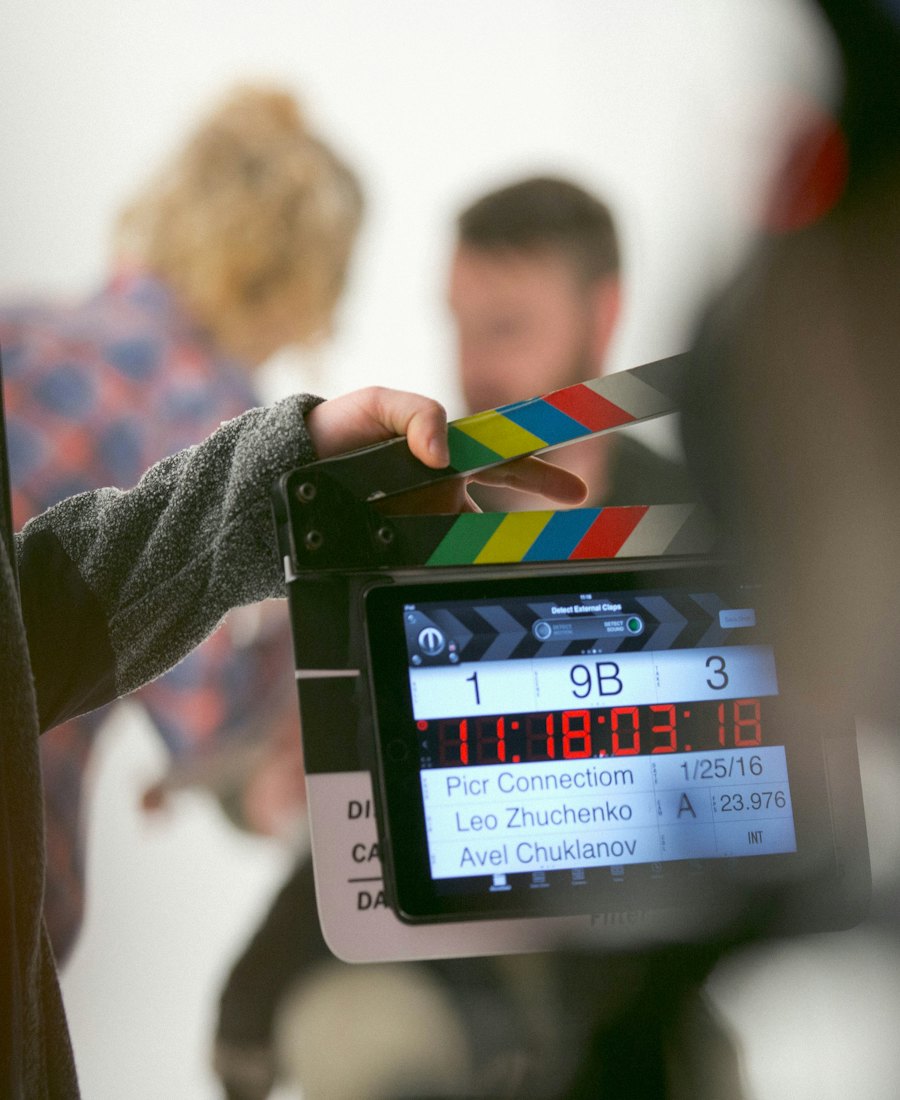 A crew member holding a timecode clapperboard on set