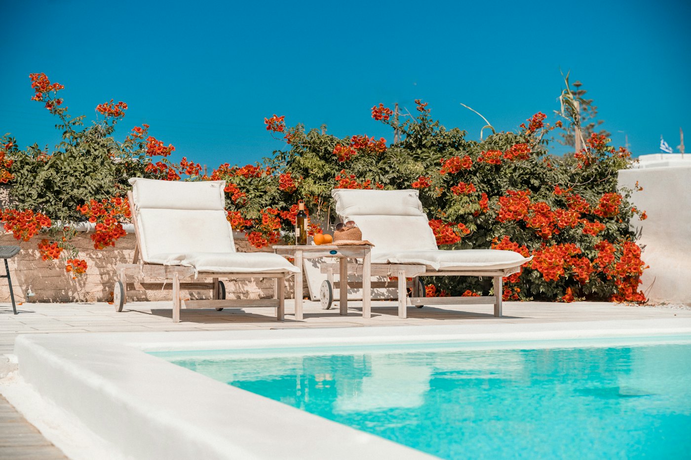Kalkan'da begonviller arasında havuz başı şezlonglar