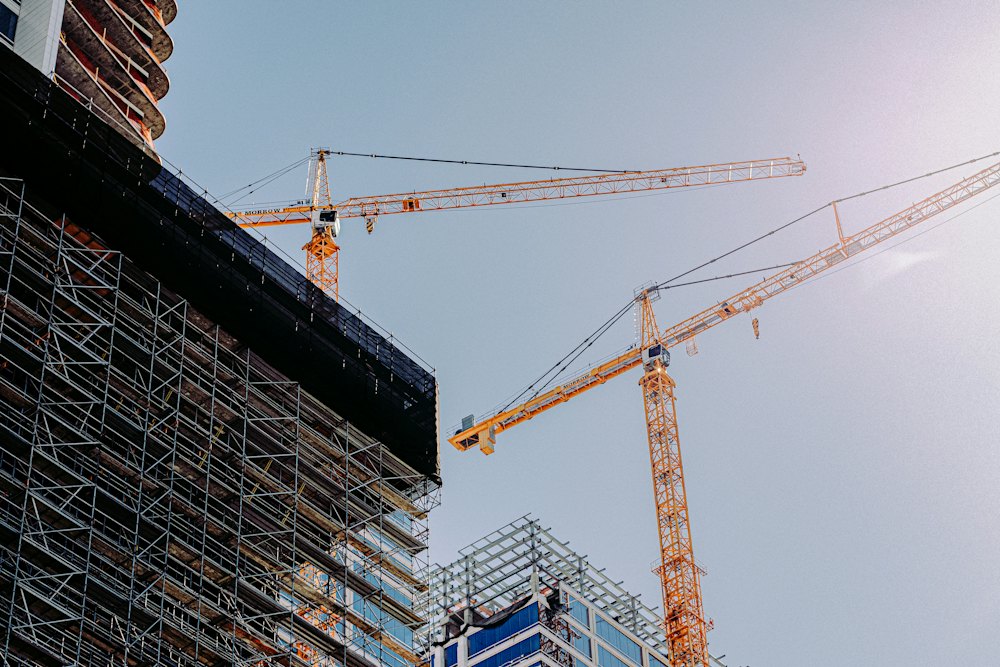 Kule vinçleriyle yükselen betonarme bir yapının iskeleli cephesi